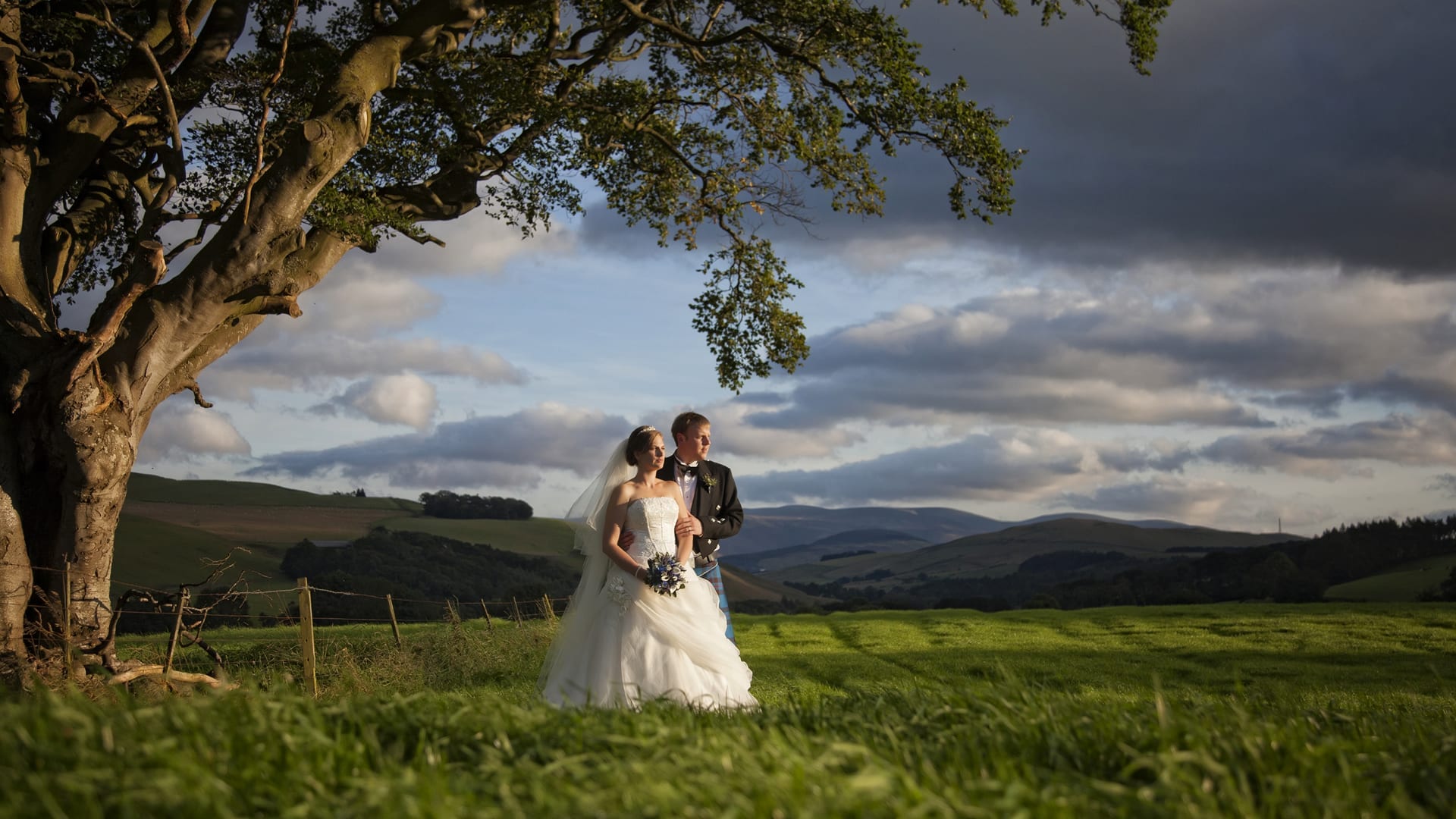 Bride and groom with backdrop of hills behind at Barony Castle